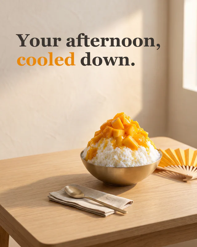 Bingsu on an oak table with a folded paper fan and a brass spoon, headline "Your afternoon, cooled down."